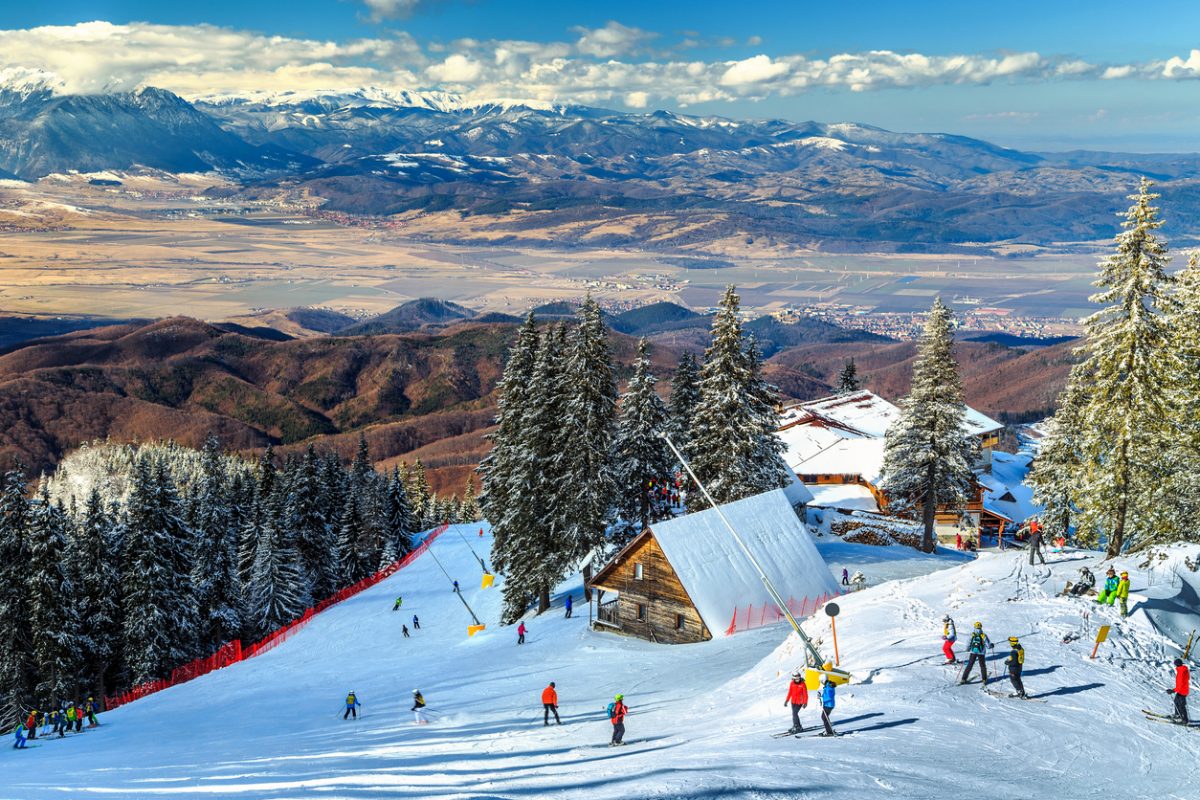 Transylvania Heliski in Romania - a ski slope with people skiing down it.