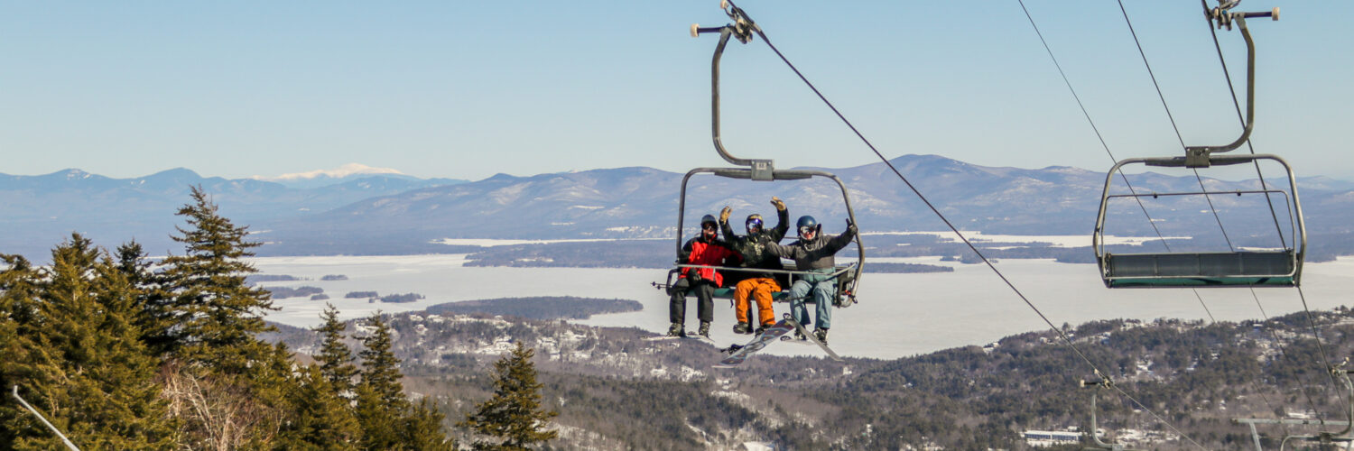 Gunstock Mountain Resort in USA - two people on a ski lift in the mountains.
