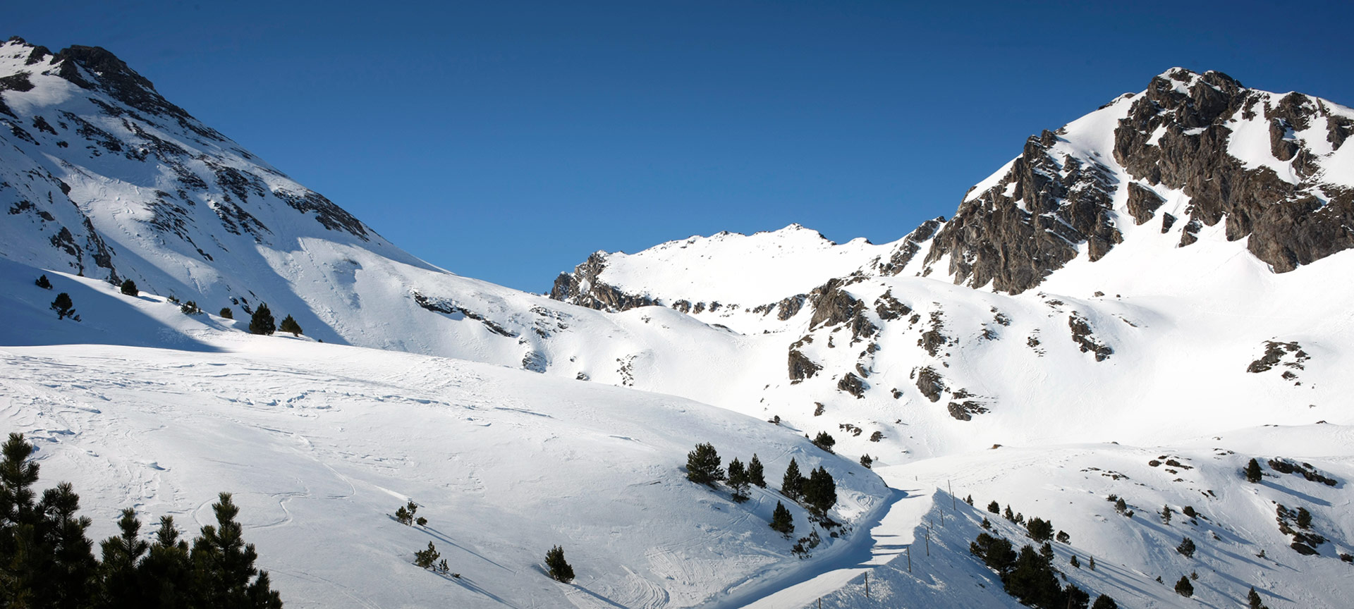 Espot Esqui in Spain - a snow covered mountain with trees in the fore.
