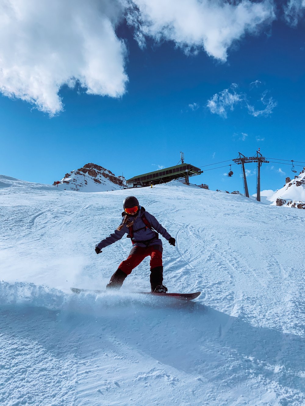 Schlick 2000 in Austria - a man riding a snowboard down a snow covered slope.
