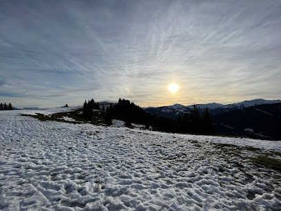 Austrian winter sports scene at Ski Juwel Alpbachtal Wildschönau - Markbachjochbahn, featuring a chalet nestled in a stunning, snowy mountain landscape.