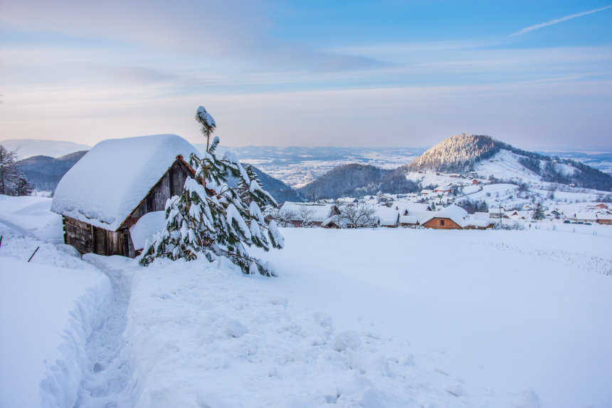 Skijalište Jarki in Croatia - a small house covered in snow with mountains in the background.