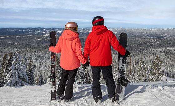 A family enjoying a day of skiing at Dodge Ridge resort in Pinecrest, California, amidst stunning winter scenery featuring a ski lift.