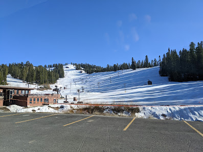 Ski resort at Dodge Ridge, Pinecrest, filled with winter sport enthusiasts. The scene features snow-covered slopes, icy conditions and a busy ski lift.