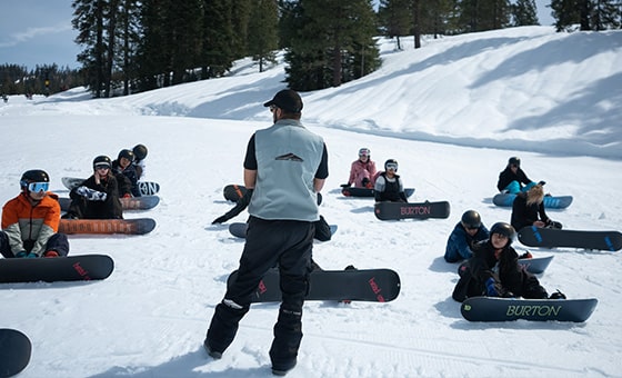 A snowboarder skillfully gliding down the snowy slopes of Dodge Ridge in Pinecrest California. The winter scene is serene and the pristine snow sparkles under the sunlight.