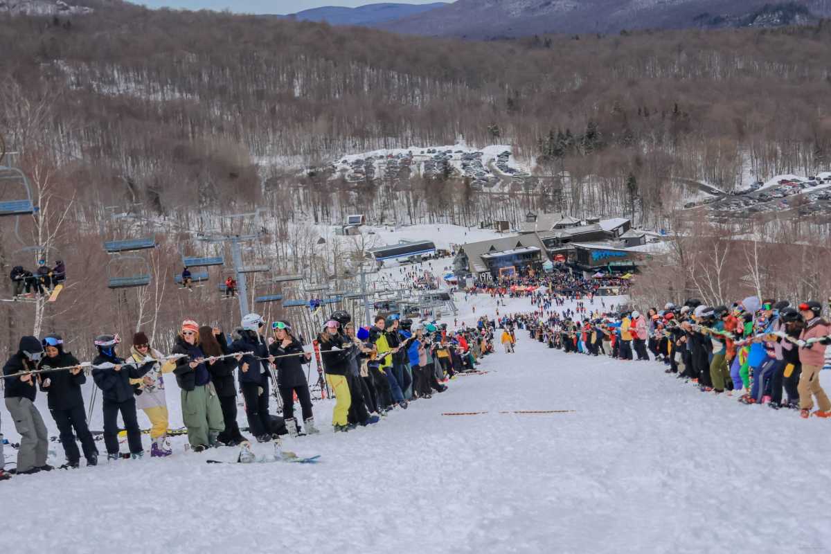 Mont-Orford in Canada - a group of people standing on top of a snow covered slope.