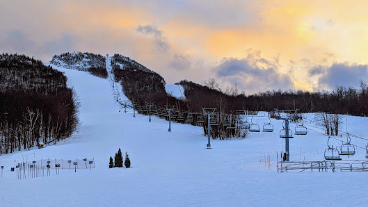Ski resort at Mont-Orford in Quebec featuring winter sports scene with a ski lift, snow-covered slopes and stunning winter scenery.