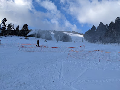 A busy day at the Great Divide ski resort in Marysville, Montana with various winter sports enthusiasts. A charming chalet nestled amidst the snowy landscape, serving as the hub for this winter sports centre.