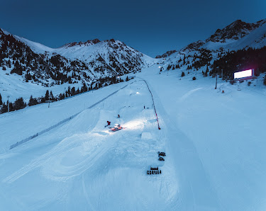 Winter sports enthusiasts enjoying the snowy slopes at Shymbulak ski resort in Almaty, Kazakhstan, with a ski lift visible in the background.