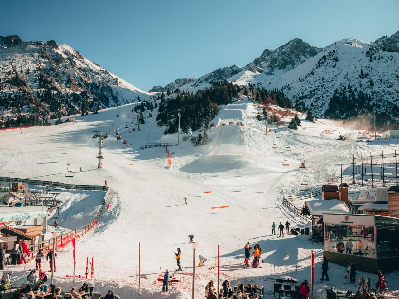 Shymbulak in Kazakhstan - a group of people skiing down a snowy slope.