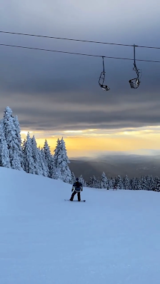 A skier glides down a snowy slope at Uludag Ski Center in Bursa, Turkey, with a ski lift visible in the background, indicative of a vibrant winter sports scene.