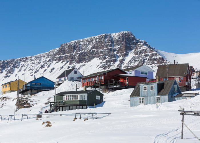 A winter sports scene on Disko Island Greenland featuring a ski resort surrounded by snowy landscapes. A quaint chalet lies nearby adding to the scenic charm of this winter sports centre.