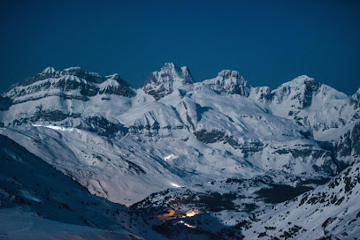 Exterior view of Lotte Arai Resort in Honshu, Japan, showing a snowy mountain, a winter sports scene, a charming chalet, and neighboring mountain hut, all set in the picturesque setting of a bustling ski resort.