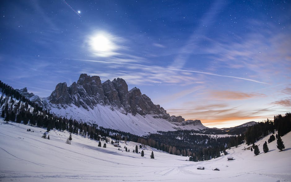 Monte Bondone in Italy - the moon shines in the sky above a snow covered mountain.