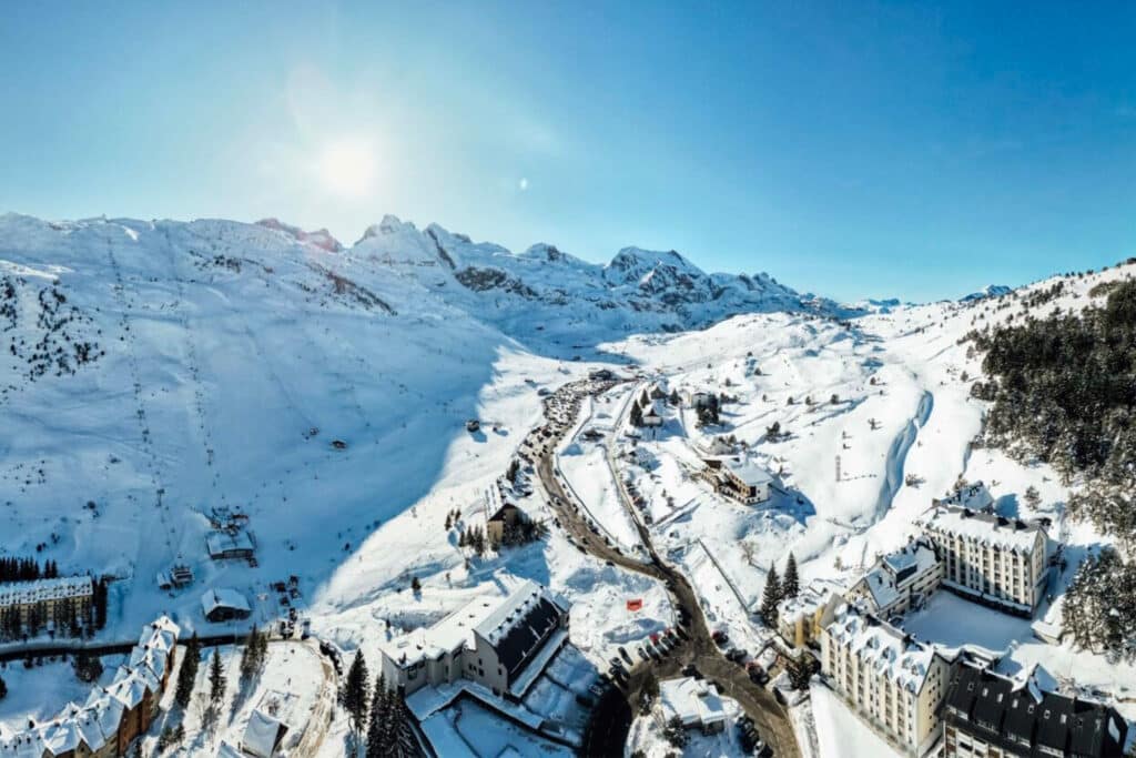 A picturesque view of Astún Ski Resort in Aragon Spain featuring a charming chalet nestled against snow-covered slopes epitomizing the beauty of winter sports scene.