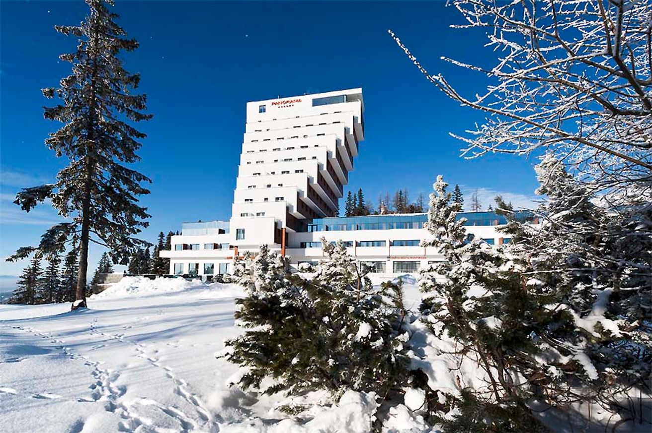 Štrbské Pleso in Slovakia: a white building surrounded by snow covered trees.