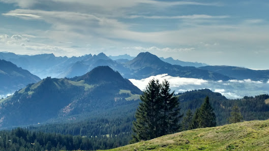 View of the stunning mountain landscape in La Berra, Switzerland, with a cozy chalet nestled amidst the serene environment. Winter sports enthusiasts enjoy the ski resort facilities.