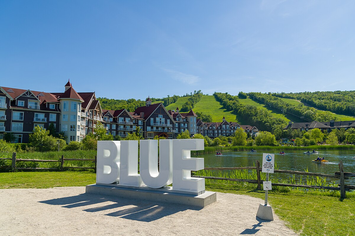 Blue Mountain Resort in Canada - a large white sign sitting in front of a lake.