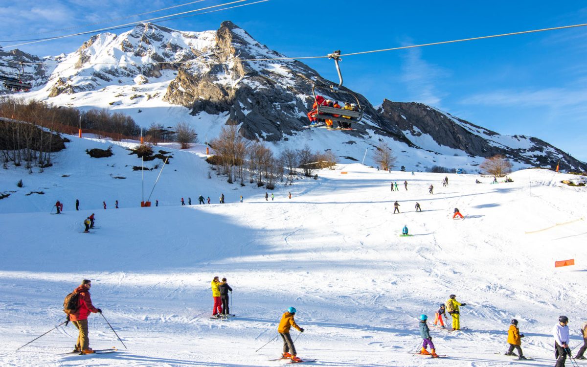 Station Gourette in France - a group of people skiing down a mountain.
