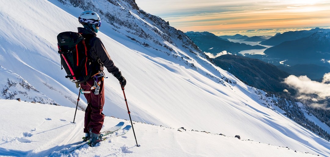 A skier and snowboarder enjoying winter sports at the Garibaldi At Squamish ski resort in Vancouver, British Columbia, Canada with a chalet in the background.