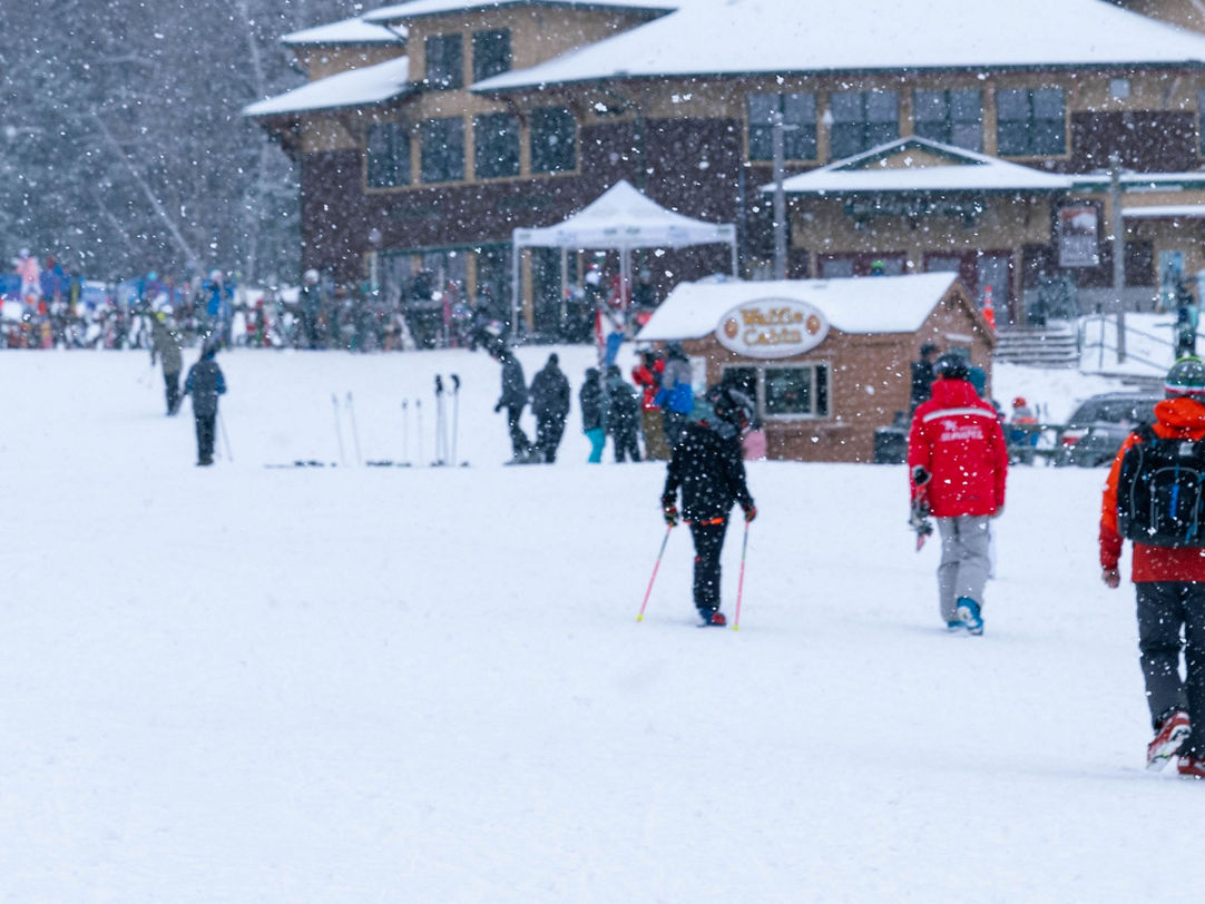 Mt Sunapee in USA - a group of people walking through the snow.