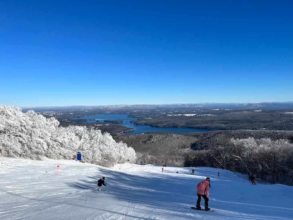 Mt Sunapee in USA - a group of people skiing down a snowy slope.