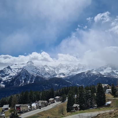 A scenic view of Manzherok ski resort in Altai Republic Siberia featuring vast snowy mountains a cozy chalet and winter sports enthusiasts enjoying their activities.