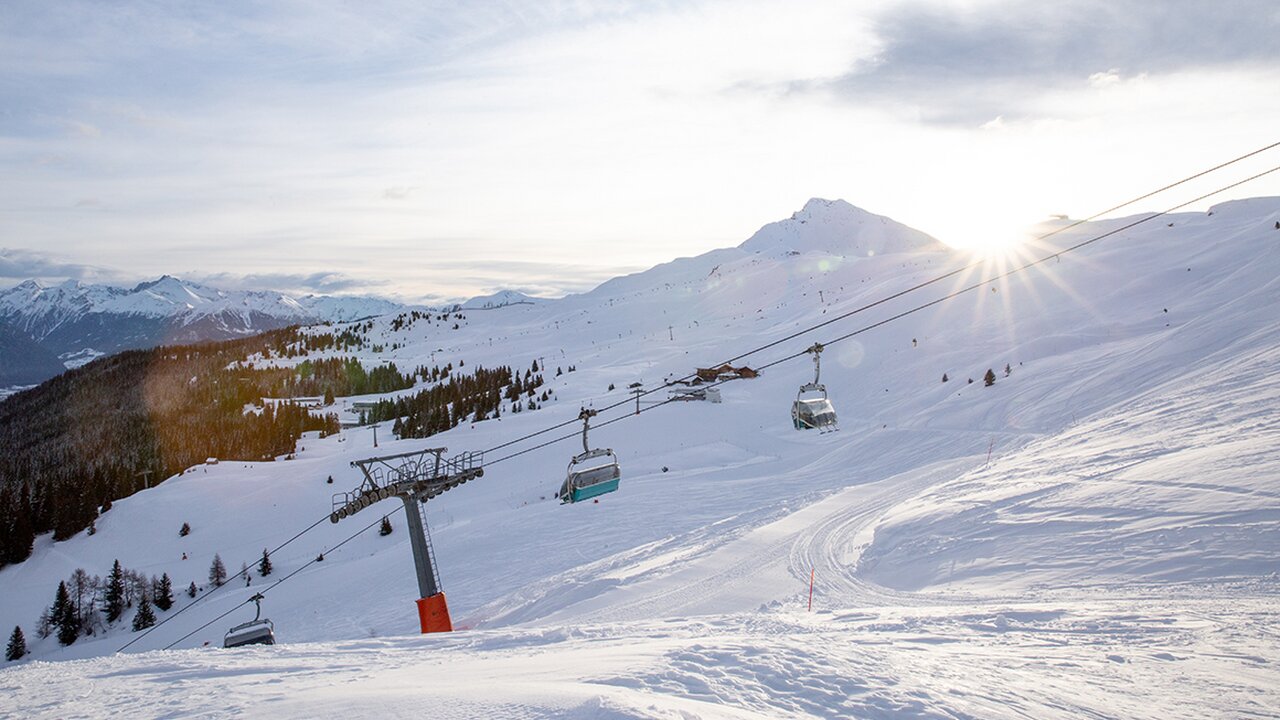 Racines-Giovo in Italy - a ski lift going down a snowy slope.
