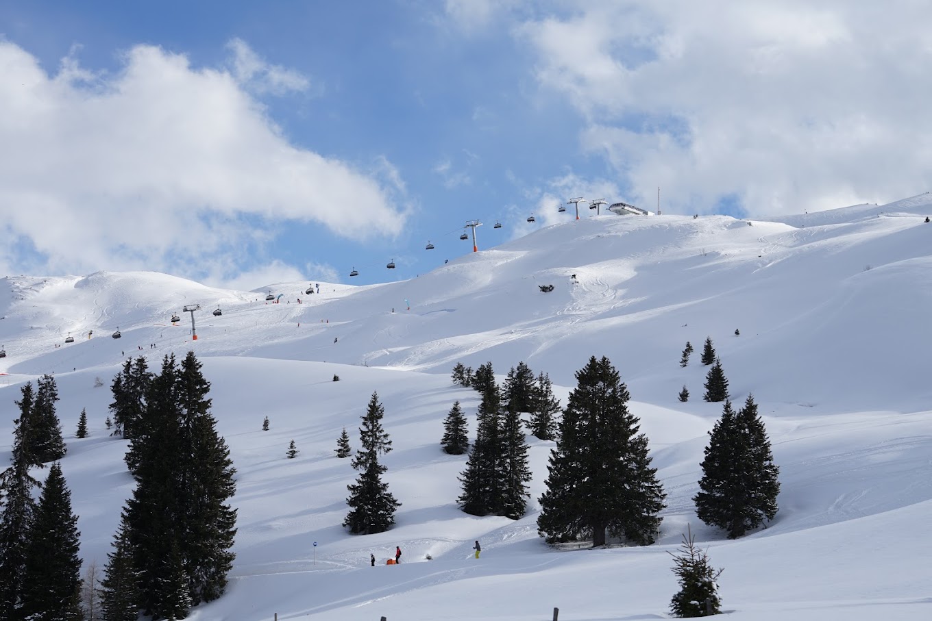 Racines-Giovo in Italy - a group of people skiing down a snow covered mountain.