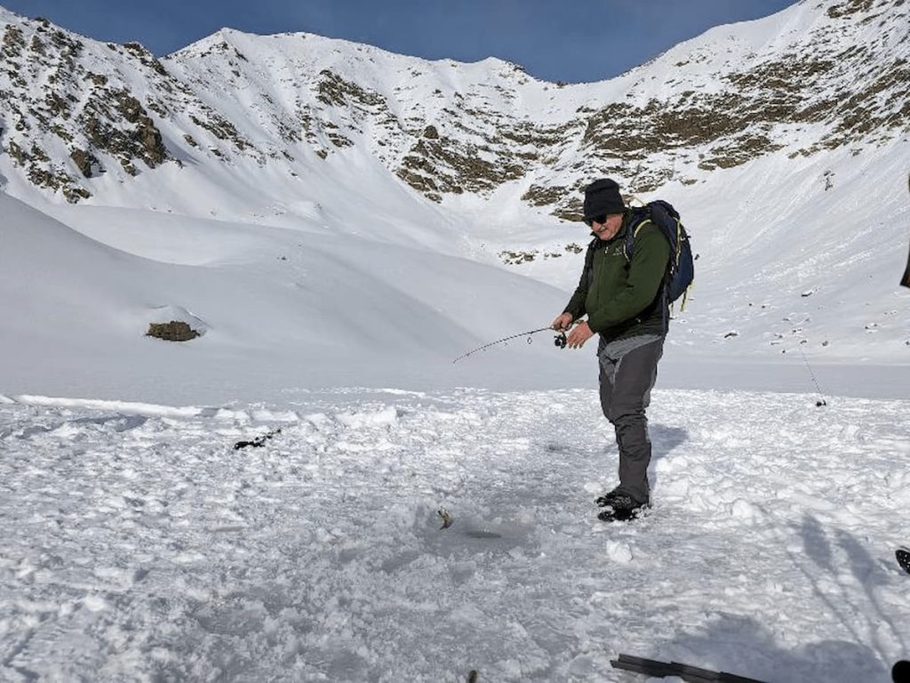 Nuova Carì in Switzerland - a man walking across a snow covered mountain.