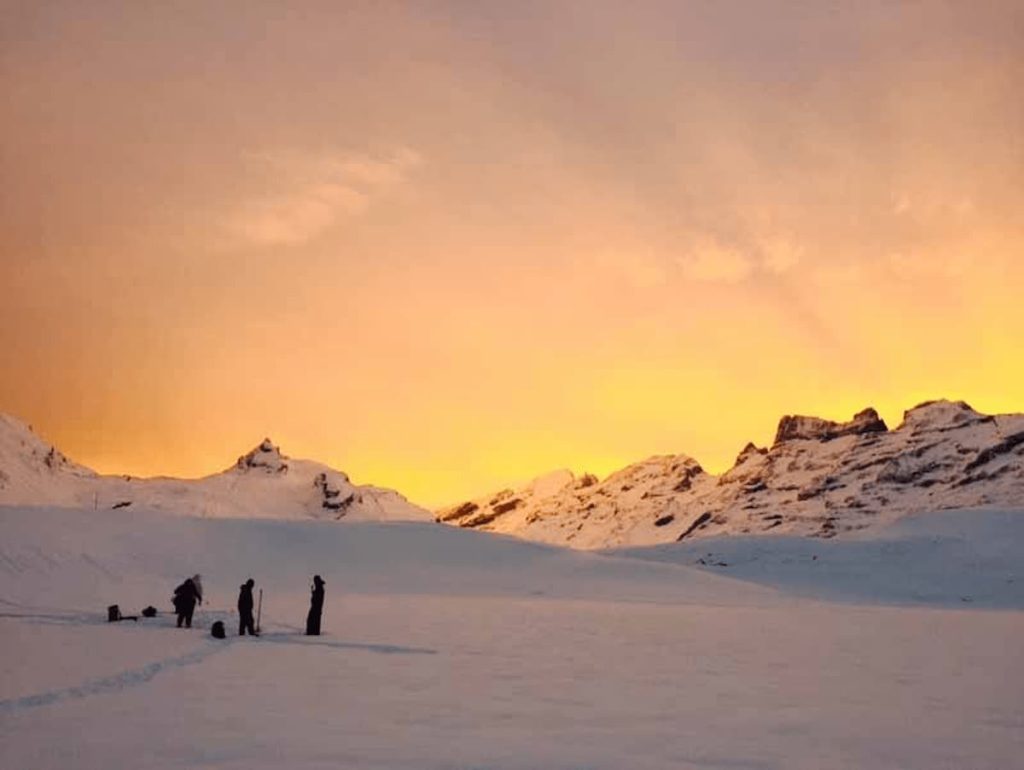 Nuova Carì in Switzerland - a group of people walking across a snow covered mountain.
