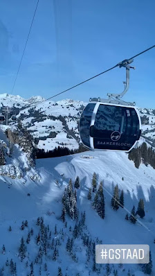 Image of skiers at Wasserngrat Bergbahnen, a Swiss ski resort in Bern. A ski lift ascends the snowy mountain amidst chalets, creating a picturesque winter sports scene.