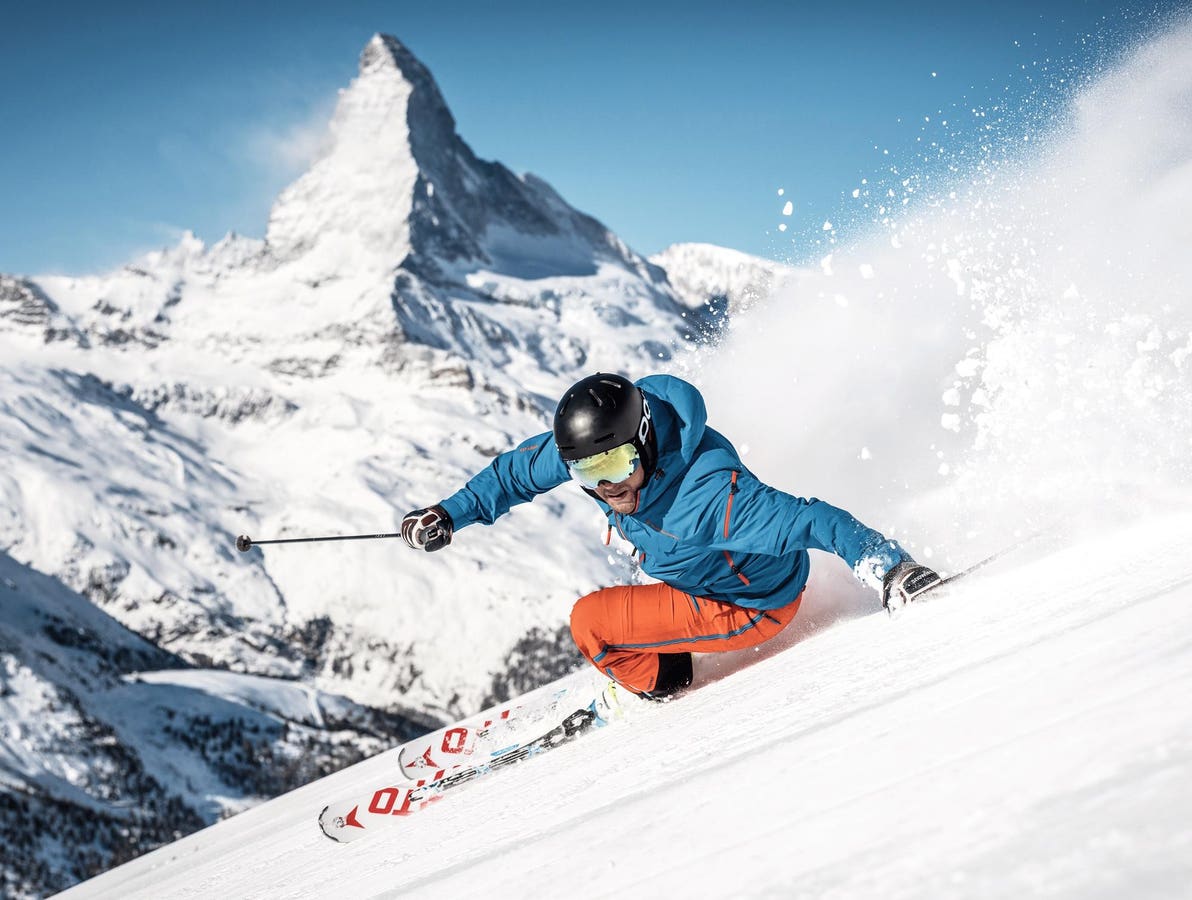 Wasserngrat Bergbahnen in Switzerland - a man in a blue jacket skiing down a mountain.