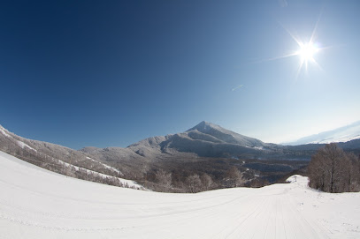 Winter scene at Montecampione Ski Area, Italy, featuring a ski resort nestled in the mountain landscape with chalet and a skier enjoying the snowy terrain.