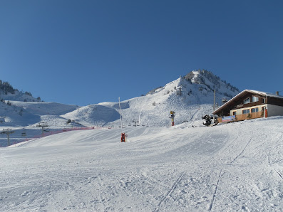 A view of the vibrant Hirmentaz | Les Habères – Bellevaux | Habère-Poche winter sports centre in Mont Blanc featuring a ski resort with a charming chalet. A skier navigating the snowy scene.