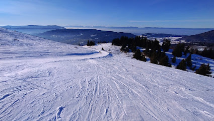 Winter sports enthusiasts enjoying the slopes at the Hirmentaz | Les Habères – Bellevaux | Habère-Poche ski resort in Haute-Savoie, Mont Blanc, France, with a quaint challet nearby.