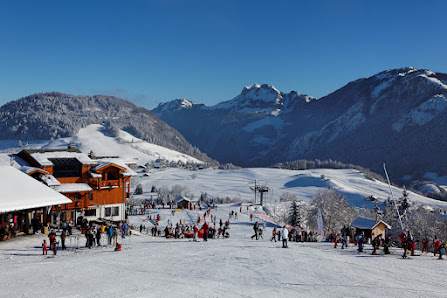 Winter scene at Hirmentaz ski resort in Haute-Savoie, France, featuring bustling winter sports activities, a cozy chalet, and stunning snow-covered scenery.
