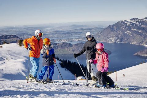 A family enjoying a day of skiing at the Klewenalp | Stockhütte – Beckenried | Emmetten ski resort in Nidwalden Central Switzerland showcasing a typical winter sports scene.