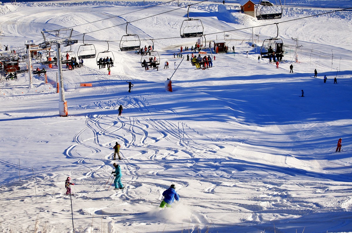 Alpe du Grand Serre in France - a group of people skiing down a snowy hill.