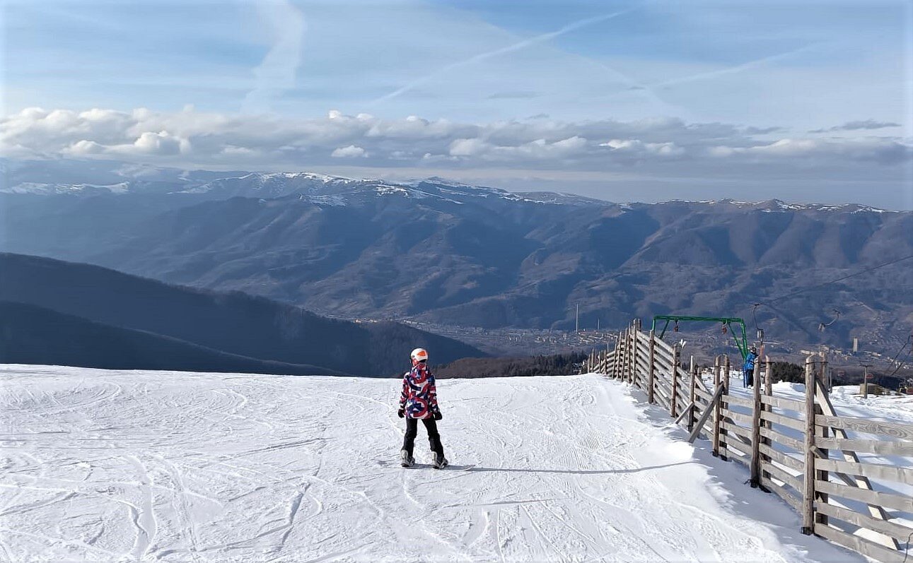 Straja in Romania - a person standing on top of a snow covered mountain.