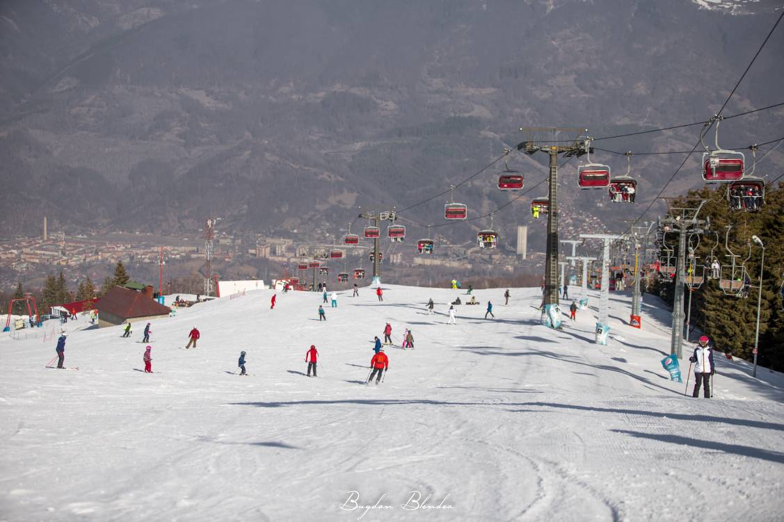Straja in Romania - a ski slope with people skiing down it.