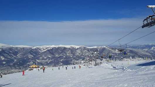 Ski resort in Straja, Romania, featuring winter sports activities, a cozy challet, impressive winter scenery and a ski lift.