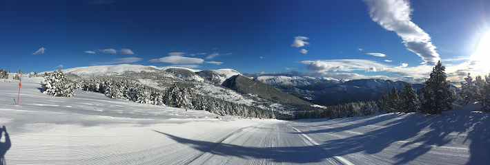 A picturesque view of Lookout Pass in Mullan Idaho featuring a charming challet nestled among snow-covered mountains. Winter sports enthusiasts can be seen in action in this well-loved ski resort. A quintessential winter paradise.