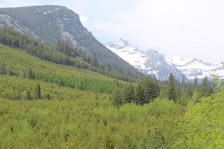 View of Lookout Pass in Mullan Idaho showcasing a beautiful mountain range with a chalet at the base. A ski resort complete with ski lift can also be seen as well as a mountain bike nearby.