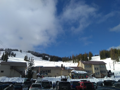 Image of Lookout Pass in Mullan, Idaho, showcasing a popular ski resort. The scene includes a ski lift, mountains covered in white snow, capturing a winter sports atmosphere.