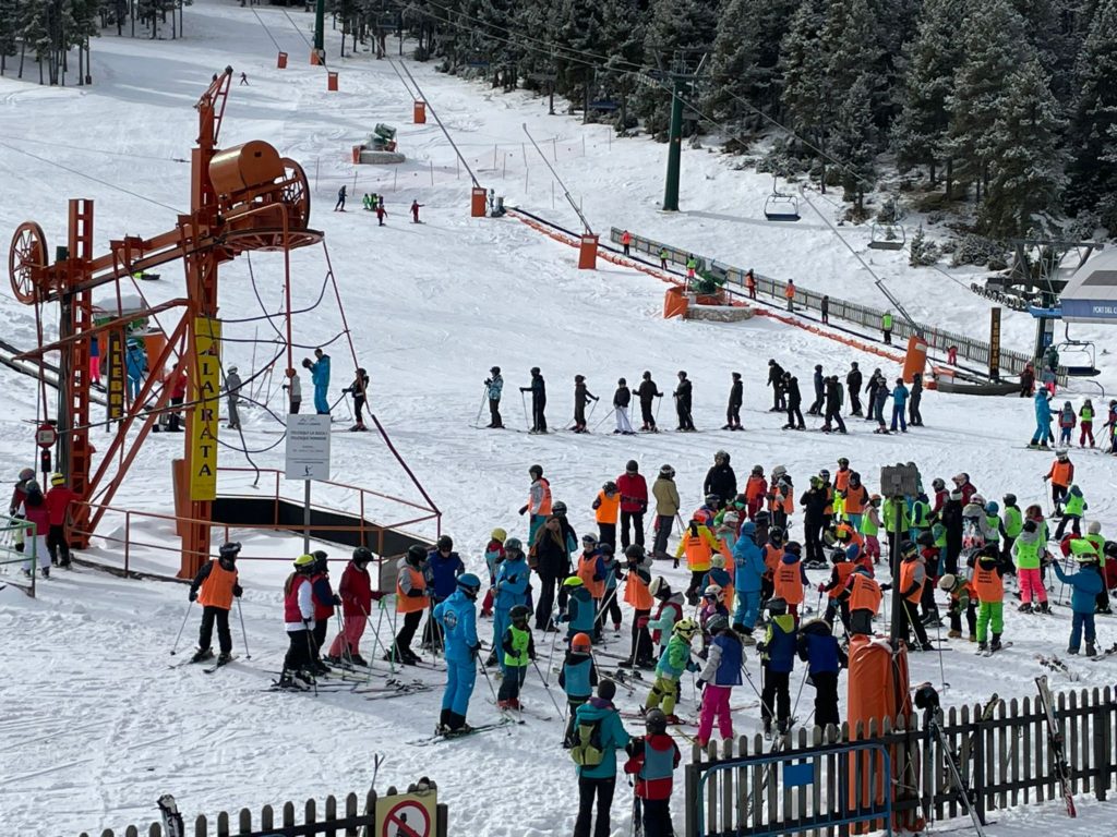 Port del Comte in Spain - a group of people standing on top of a ski slope.
