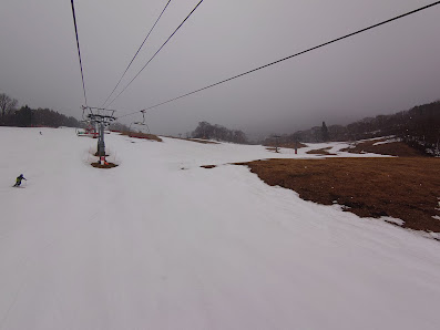 A ski resort in Port del Comte Catalonia Spain with a ski lift navigating the snowy slopes. Skiers prepare for their descent down the mountain in this winter sports scene.