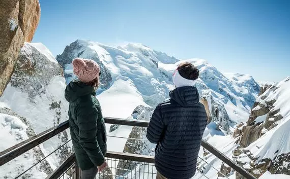 Chamonix Mont-Blanc in France - two people looking out over the snowy mountains.