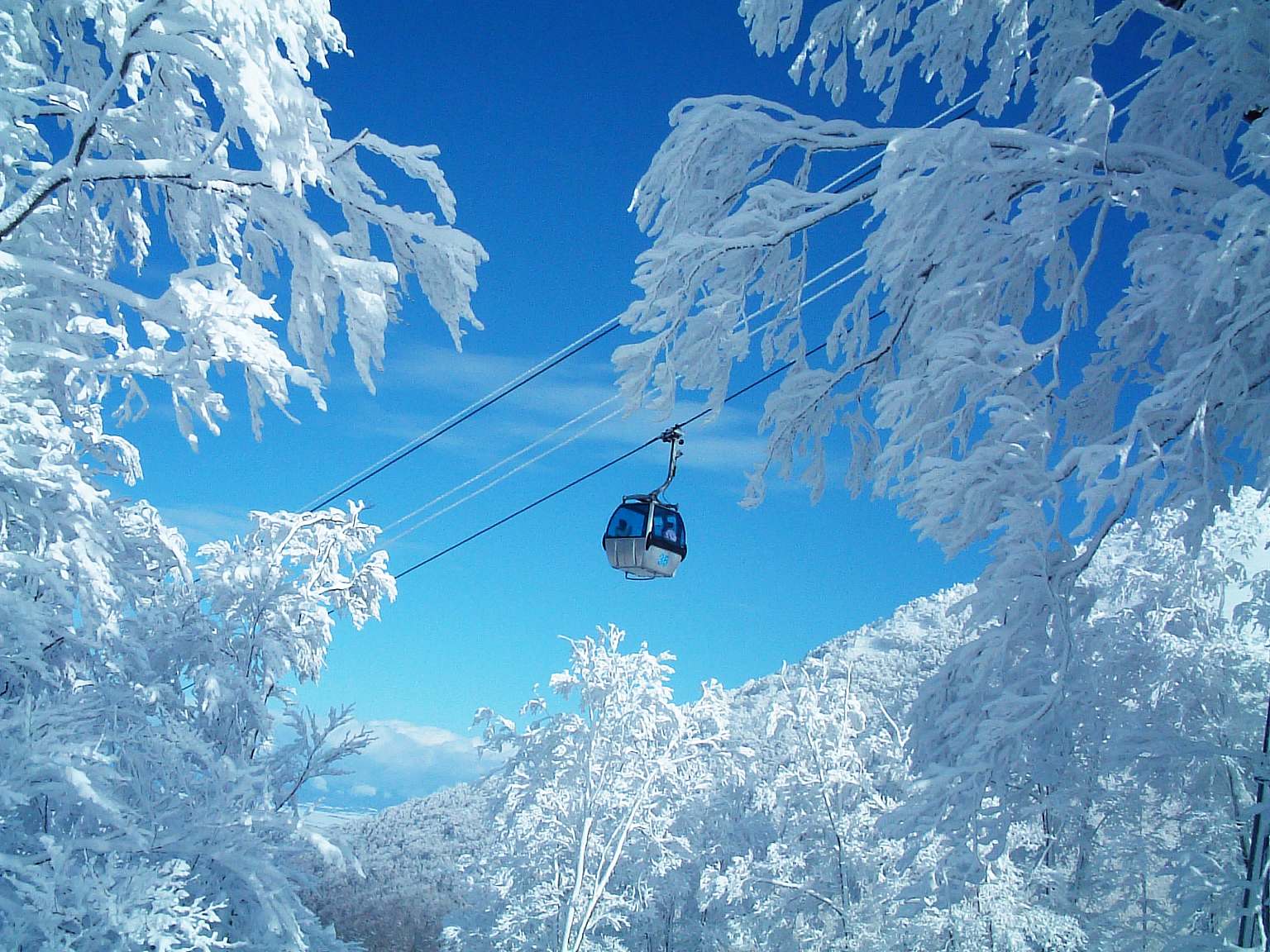 Aomori Spring in Japan - a ski lift going up a snowy hill.