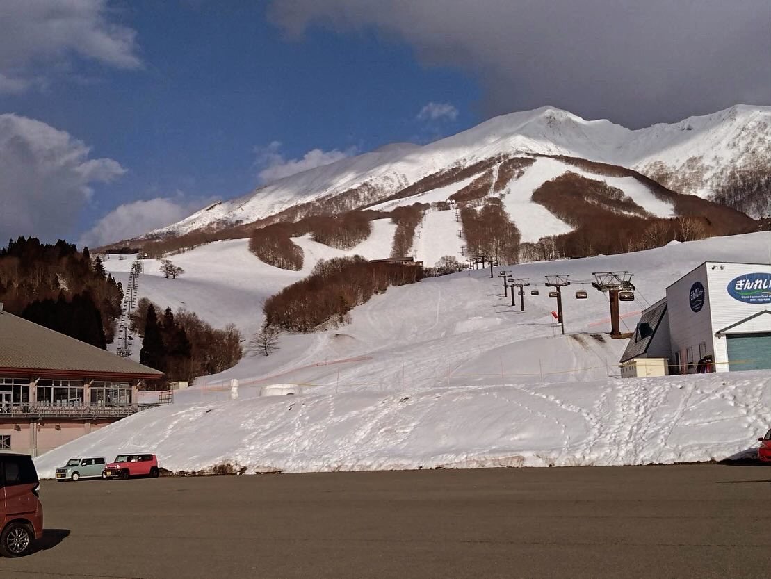Akitaken – Tazawako in Japan - a red truck parked in front of a mountain.